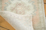Distressed blush and seafoam pile texture with original selvedge and hand-knotted backing of vintage Oushak rug.