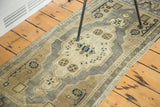 Ivory lozenge medallion with royal blue pinwheel adornments on a vintage Turkish Oushak rug.