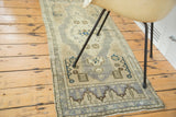 Vintage Oushak runner end panel with geometric and stylized motifs in sand and blue tones.