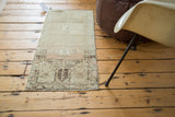 Faded charcoal geometric motifs, peach, ivory, and abrash on vintage Oushak rug.