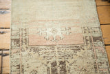 Vintage Oushak rug with muted peach, ivory, and charcoal geometric patterns, showing abrashes.