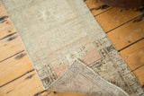 Folded corner of the vintage Oushak rug, revealing soft ivory, peach pile and hand-knotted foundation.