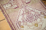 Serrated geometric medallion and original cord selvedge on a mauve vintage Oushak rug.