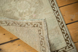 Vintage distressed Oushak rug corner revealing hand-knotted back and original selvedge.