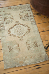 Curvilinear medallion with expressive scrolling outline on the vintage Oushak rug's soft ivory field.