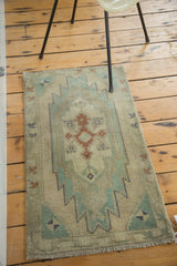 Vintage Oushak rug with serrated zigzags and arrowheads in mint green, copper, and denim.