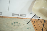 Vintage Oushak rug corner with oxidized copper green rams horn spandrel and intact selvedge.