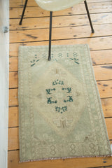 Traditional Oushak rug corner with beige field and soft copper green ram's horn spandrel.