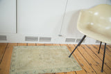 Vintage Oushak rug corner showing intact side cord selvedge and faded pistachio border.