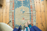 Distressed antique Northwest Persian runner's aqua blue field, geometric medallion, and patterned border.