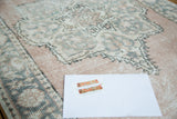 Vintage Oushak rug runner, distressed pale blush field with aqua and ivory medallion detail.