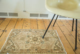 Upper corner of a vintage Malayer rug showcasing geometric patterns and barber pole border with green accents.