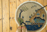 Vintage Chinese round rug showing an aqua blue village pagoda and flying birds.