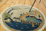 Vintage Chinese pictorial round rug detail: blue water, village, and fringe.