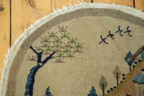 Hand-knotted pile's even wear, showcasing a dark blue tree, green foliage, and birds.
