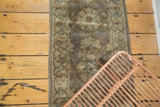 Faded hand-knotted European rug with floral patterns and bubbly geometric border.