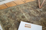 Vintage European rug pile with faded brown, beige, and bronze tones showing even wear.