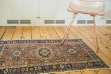 Faded gem-tone brick red, teal, and saffron geometric Karaja rug with floral border.