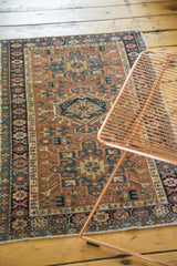 Geometric pattern in brick red, teal, navy, saffron gold, with mostly even wear.