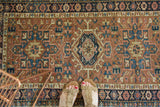 Detailed view of the Karaja rug's floral border and geometric patterns, with softened tones.