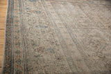 Close-up of heavily distressed antique Khorassan carpet with exposed foundation, faded rust, blue, ivory tones.