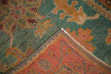 Hand-knotted Oushak rug's fold, revealing weave, denim blue, aqua, and rosy rust tones.
