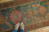 Vintage Oushak rug runner, aqua green and rosy rust design, showing even wear under feet.
