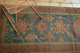 Oushak runner detail with denim blue field, rosy rust floral patterns, and visible pile wear.
