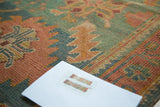 Rosy rust, aqua green, and bronze linear floral design of the vintage Oushak rug.