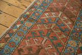 Close-up of vintage Heriz rug runner, with brick red geometric motifs and sky blue floral border.