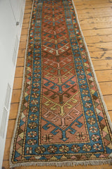 Antique Heriz runner lower corner with brick red geometric arrowhead, sky blue floral and diamond borders.