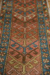 Detail of antique Heriz runner's geometric arrowhead motif and patterned blue border.