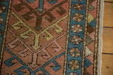 Side detail of antique Heriz runner, featuring brick red field, sky blue floral border, and alternating diamond pattern.