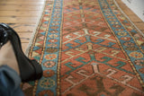 Antique Heriz runner pile, brick red geometric arrowhead design with blue floral inner border.