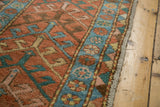 Antique Heriz runner: geometric brick red field, sky blue floral inner border, diamond outer edge, fringe.