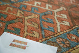 Textured pile of hand knotted antique Heriz runner, brick red, sky blue, and celadon green.