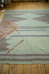 Secured end and subtle stripes of the vintage sea foam green Turkish Kilim carpet.