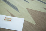Flat weave texture of vintage Turkish Kilim carpet, with abstract pattern in muted green, taupe, and grey.