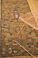 Intricate hand-knotted expressive floral patterns in gold, pink, and blue on antique Karabagh rug.