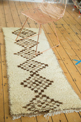 Vintage Moroccan runner featuring repeating checkered diamond patterns and plush pile.