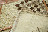 Secured hand-stitched edge and tightly woven ivory back with brown markings on Moroccan runner.