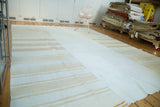 Vintage hand woven patchwork Kilim rug with plain ivory center and varying beige stripes.