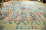 Detail of the handwoven New Kilim carpet, showing geometric patterns in pale cranberry, sky blue, saffron.