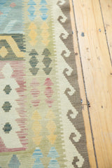 Paneled geometric Kilim rug section with dark brown scroll border, sky blue, saffron.