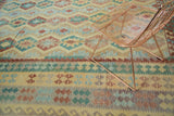 Pakistani Kilim carpet detail of abrashed geometric bands in blue, yellow, red, and green.