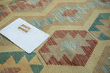 Detail of new handwoven Pakistani Kilim showing geometric medallions in powder blue, cranberry, and beige.
