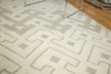 Hand-woven texture of the abstract geometric pattern on the ivory and grey Kilim carpet.