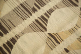 Hand woven modern Kilim rug with textured ivory, brown, and mellow gold geometric pattern.