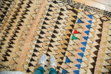 Plush vintage Moroccan rug featuring bold geometric ivory, charcoal, and colorful triangles.