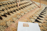 Plush pile of a vintage Moroccan rug showcasing ivory, blush, and bold charcoal patterns.